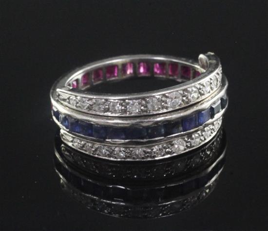 A mid 20th century platinum, sapphire, ruby and diamond triple band swivel ring, size M.